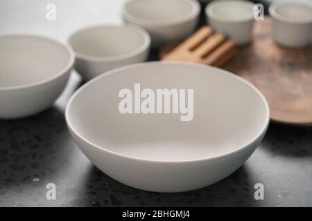 Empty matt white ceramic handmade tableware set on concrete countertop Stock Photo
