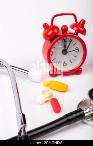 A picture of stethoscope, medicines and clock. It is for medical reminder. Stock Photo