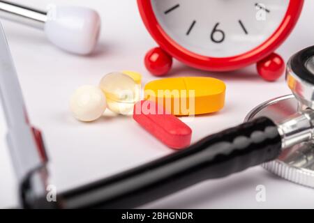 A picture of stethoscope, medicines and clock. It is for medical reminder. Stock Photo