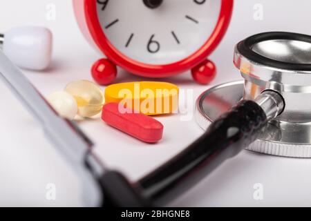 A picture of stethoscope, medicines and clock. It is for medical reminder. Stock Photo