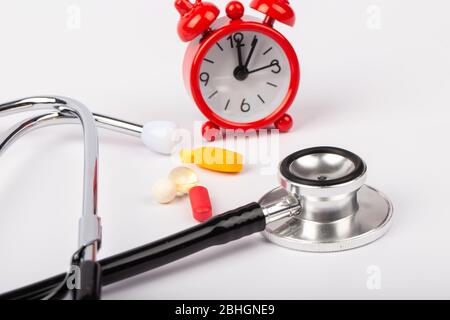 A picture of stethoscope, medicines and clock. It is for medical reminder. Stock Photo