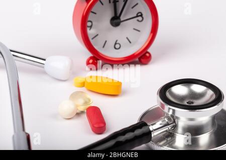 A picture of stethoscope, medicines and clock. It is for medical reminder. Stock Photo