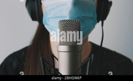 Healthcare worker in call center with medical mask speaking into the microphone. Covid-19 support line, customer service. Stock Photo