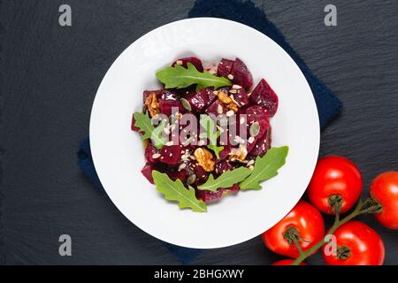 Healthy Vegetarian summer food concept Homemade vegan beetroot and rocket salad in white ceramic plate with copy space Stock Photo