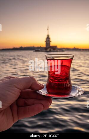 Traditional turkish tea in a glass with Maiden Tower at background in Istanbul, Turkey Stock Photo