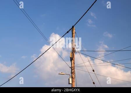 Wooden telegraph pole with power and telecoms cables attached Stock Photo