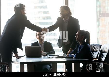 Smiling hr manager shaking successful candidate hand after interview Stock Photo