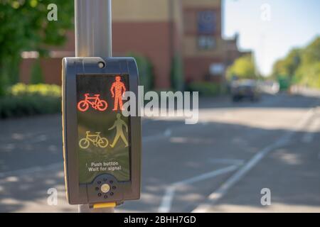 Close up of Traffic Light buttons with blurred cars in the background on a bright sunny day Stock Photo