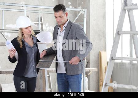 Couple of architects choose the samples of the floor and take the measures to plan the project. House buy and building goal concept Stock Photo