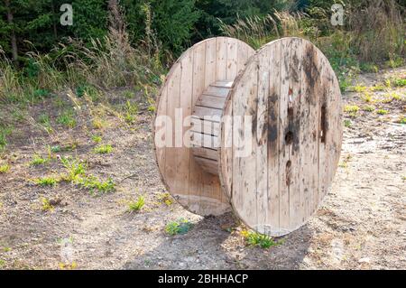 Large wooden cable spools stands on the ground Stock Photo