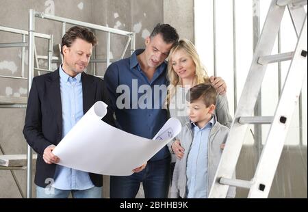 Architect showing house design plans to a family with child. Meeting at interior construction site to talk about house appearance, interior decoration Stock Photo