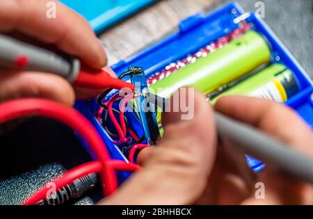 technical master soldering parts with a soldering iron. resin, the smoke, the battery, wires. technical support, repair Stock Photo