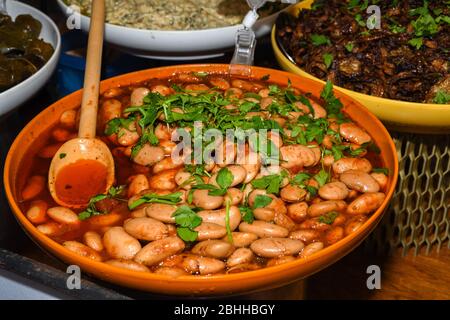 Butter beans in tomato sauce served in a very large pan, during food buffet. Fresh Food Buffet Brunch Catering Dining Eating Party Sharing Concept Stock Photo