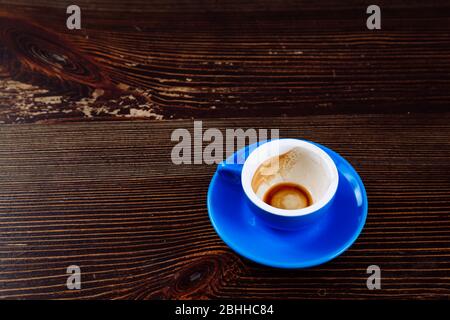 Dirty blue cup after coffee on a wooden table.  Stock Photo