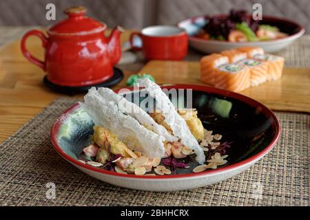 Maki rolls, fried shrimps and tea on table, Japanese cuisine restaurant Stock Photo