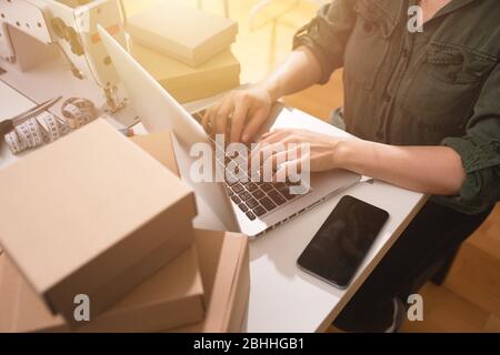 Seamstress works to new clothes ordered by internet client Stock Photo