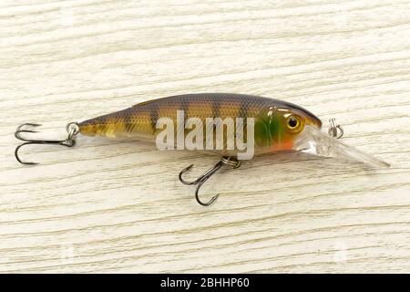 Fishing lures and wobblers are colored on the background. Stock Photo