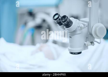 Doctor examines fundus in microscope, patient under sterile cover. Laser vision correction lasik Stock Photo