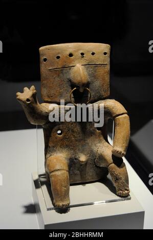 Seated human figure with tumbaga decoration. Ceramic and gold. Quimbaya culture. Integration period (1200-1500 AD). Colombia. Museum of the Americas. Madrid, Spain. Stock Photo