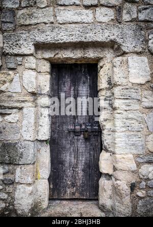 Old wooden door in a medieval wall Stock Photo