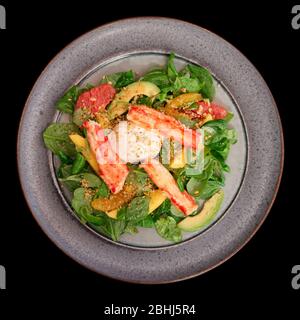 Crab meat with corn salad and citrus wedges isolated on blacke background Stock Photo