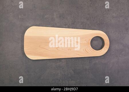 Wooden cutting board on dark kitchen table. Top view. Stock Photo