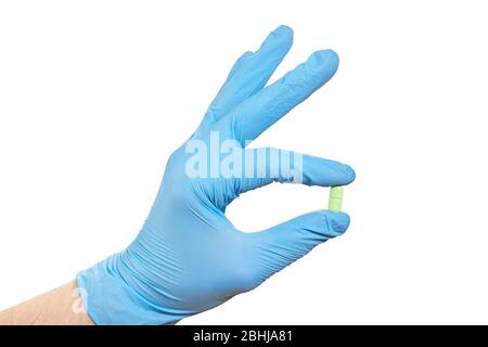 Hand in blue gloves holding pill isolated on white background Stock Photo