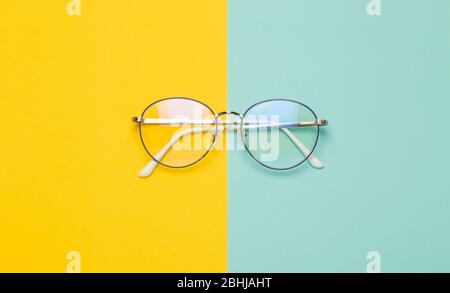 Eye glasses isolated on yellow and blue background. Stock Photo
