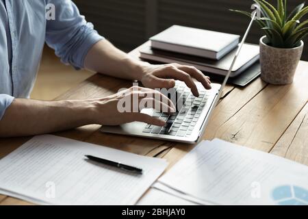 Close up businessman using laptop, sitting at work desk Stock Photo