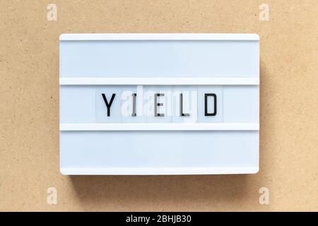 White lightbox with word yield on wood background Stock Photo