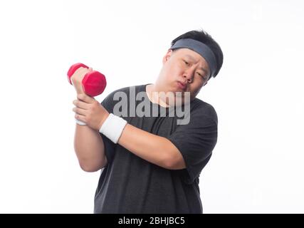Asian Funny Fat Man in sport outfits exercising with dumbbells and looking to camera isolated on white background. Stock Photo