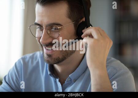 Close up smiling friendly man wearing headset talking in microphone Stock Photo