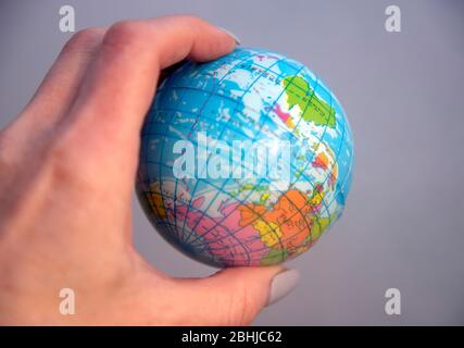 A globe in a human hand against a background of smoke.  Stock Photo