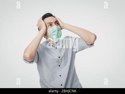 Young Asian businessman in hygienic mask shocking, 2019-nCoV or coronavirus. Airborne respiratory illness such as pm 2.5 fighting. Studio shot isolate Stock Photo