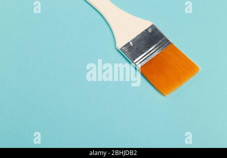 Paint brush isolated on blue background with copyspace. Stock Photo