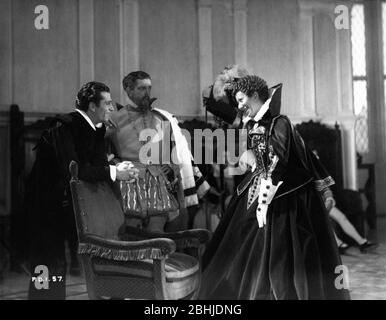 LAURENCE OLIVIER LESLIE BANKS VIVIEN LEIGH (sitting in background) and FLORA ROBSON on set candid during filming of FIRE OVER ENGLAND 1937 director WILLIAM K. HOWARD novel A.E.W. Mason screenplay Clemence Dane and Sergei Nolbandov music Richard Addinsell producers Erich Pommer and Alexander Korda  London Film Productions / United Artists Stock Photo