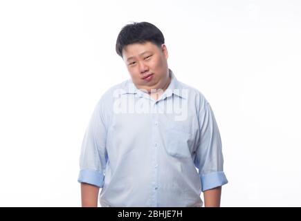 Asian fat man in blue shirt looking to camera isolated on white background. Stock Photo