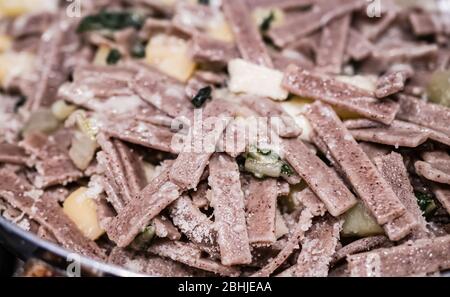 Close up of the succulent and typical Italian dish Pizzoccheri. Typical dish from Valtellina, Lombardy, Italy. Horizontal view. Stock Photo