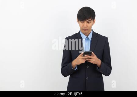Young asian businessman in black suit using smartphone isolated on white background, Online shopping, Remotely working. Stock Photo