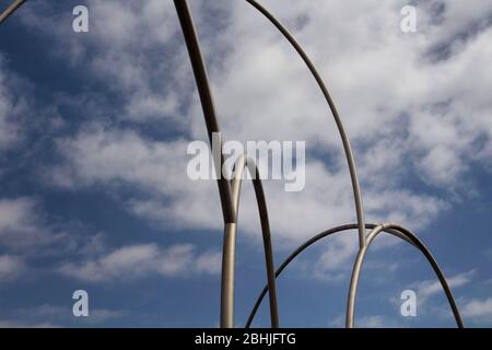 View of gigantic, modern sculpture with cloudy blue sky background in Barcelona port. It is named Waves (Onades) by Andreu Alfaro. It is a sunny summe Stock Photo