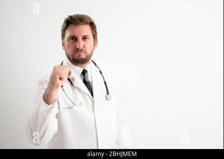 Portrait of male doctor with stethoscope in medical uniform showing fist posing on a white isolated background Stock Photo