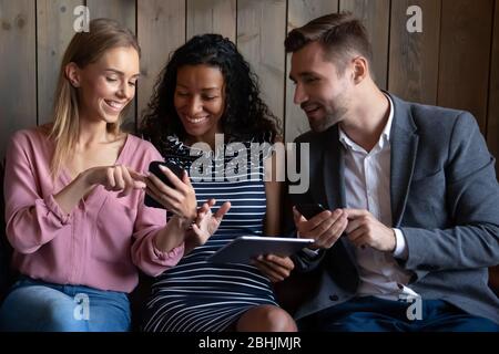 Multiracial couple relax on couch using gadgets Stock Photo