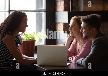 Happy couple talking with consultant in cafe Stock Photo