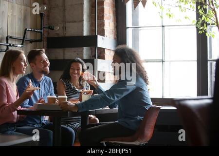Happy diverse friends have fun eating out in pizzeria Stock Photo