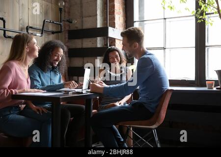 Smiling multiethnic friends have fun studying in cafe together Stock Photo