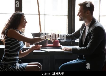 Diverse businesspeople handshake getting acquainted at meeting Stock Photo