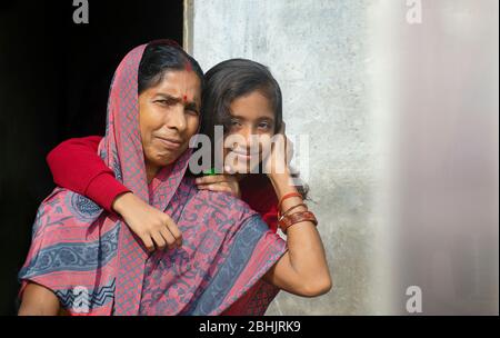 Grandmother hugs granddaughter after combing her hairs Stock Photo