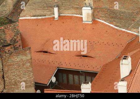 Sibiu, Romania. Traditional clay roof with eye-like openings in the attic for air flow. Stock Photo