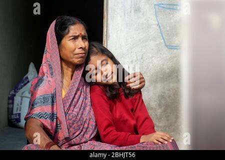 Grandmother hugs granddaughter after combing her hairs Stock Photo