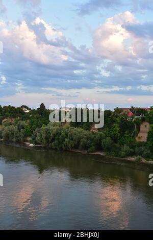 The green bank of the Danube River with several houses above the river Stock Photo